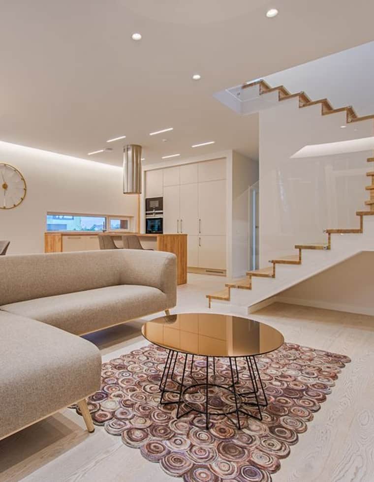 A calm, light-filled open-plan living space freshly decorated by Marwood, with a sweeping staircase and soft neutral walls