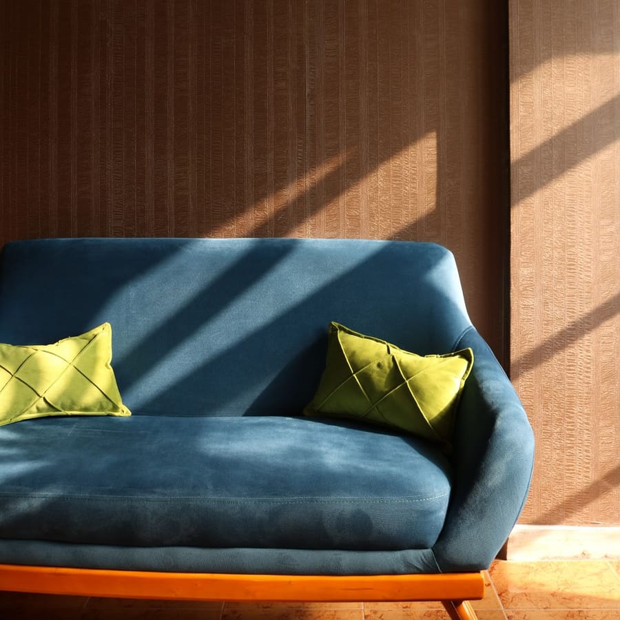 Calm wallpapered living space with warm afternoon light across a feature wall