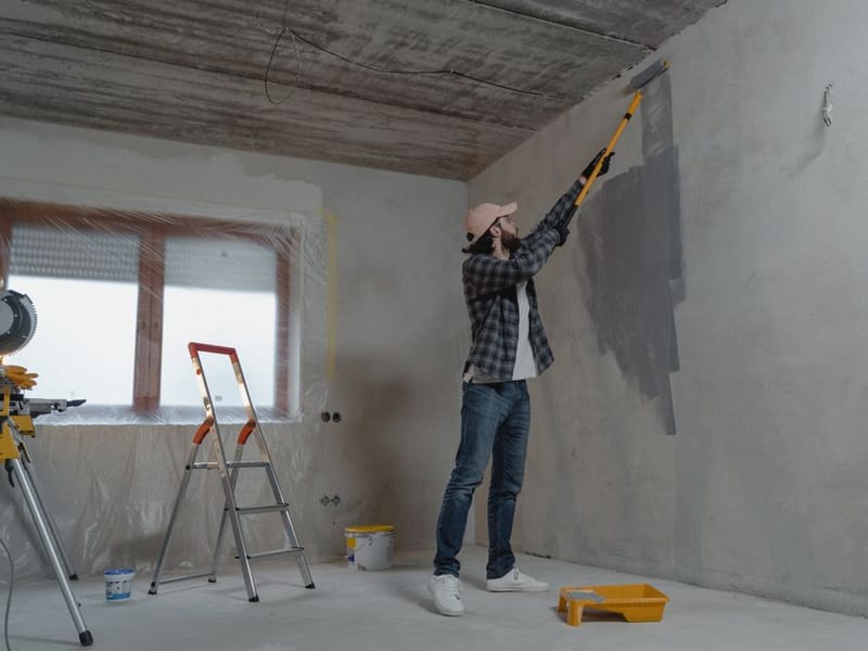Decorator cutting in a crisp paint line on a freshly painted interior wall